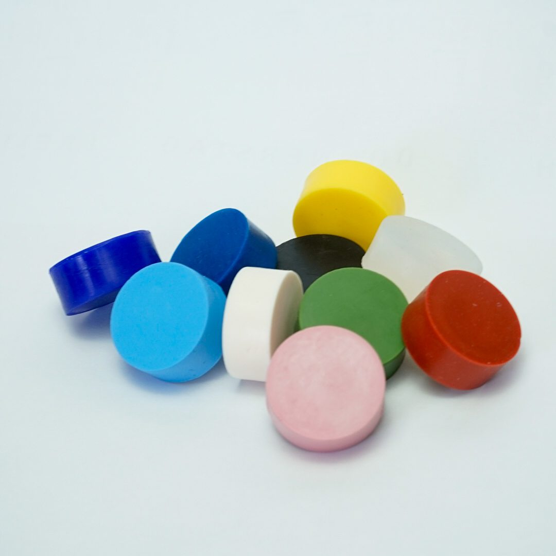 Runde Qualitätsprüfteile in blau, rot, grün, weiß, transparent, rosa, schwarz